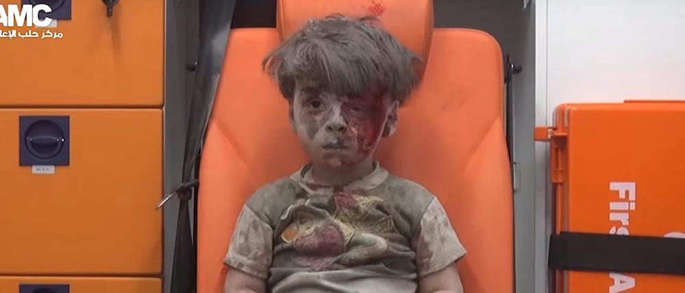 Der Videograp aus einem Handout Video der syrischen Aktivistengruppe Aleppo Media Center (AMC) vom 18.08.2016 zeigt einen vierjährigen Jungen, der am 17.08.2016 in der Stadt Aleppo (Syrien) mit blutverschmiertem Gesicht in einem Krankenwagen sitzt, nachdem ein Haus bei einem Luftangriff zerstört worden war.