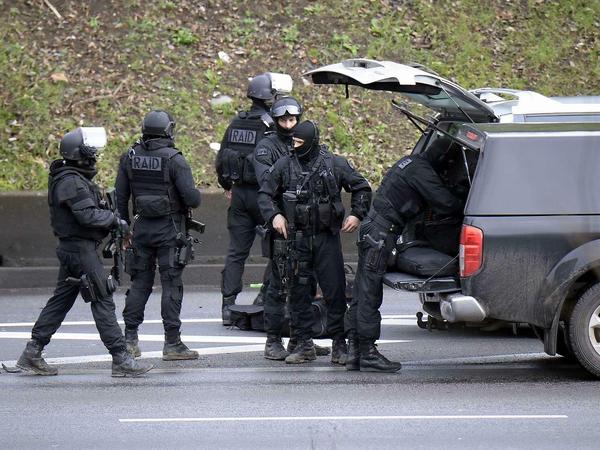 Einsatzkräfte der Spezialeinheit RAID formieren sich nach ihrer Ankunft am Port de Vincennes.