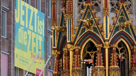 Ein Plakat zum Evangelischen Kirchentag mit dem Slogan „Jetzt ist die Zeit“ hängt an der Außenfassade des Rathauses am Hauptmarkt.