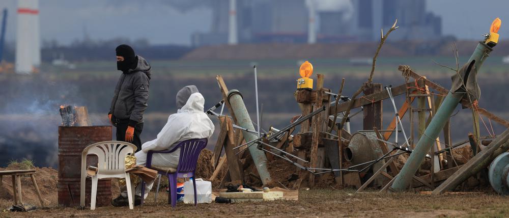 Klimaschutzaktivisten wärmen sich an einem Feuer am Rand des Tagebaus. Das Dorf Lützerath soll zur Erweiterung des Braunkohletagebaus Garzweiler II abgebaggert werden.