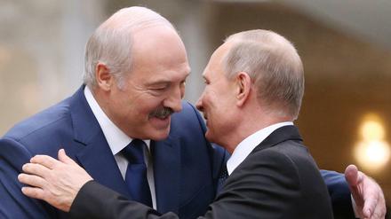 Alexander Lukaschenko (l), Präsident von Belarus, begrüßt den russischen Präsidenten Wladimir Putin während eines Gipfeltreffens