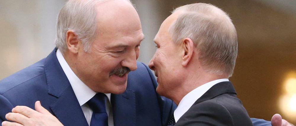 Alexander Lukaschenko (l), Präsident von Belarus, begrüßt den russischen Präsidenten Wladimir Putin während eines Gipfeltreffens