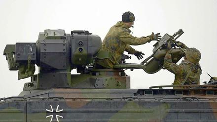 Ein Panzergrenadier reicht dem Kommandant eines Schützenpanzer vom Typ "Marder" eine Startvorrichtung für eine Panzerabwehrwaffe vom Typ "Milan".