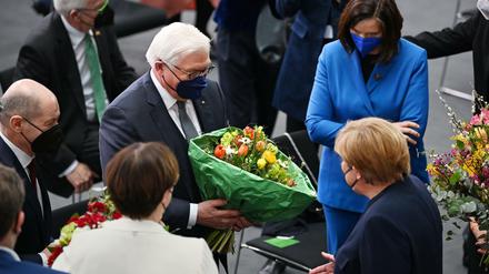 Frank-Walter Steinmeier wird von Angela Merkel beglückwünscht, links ihr Nachfolger als Kanzler Olaf Scholz. 