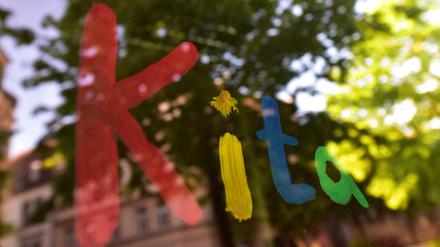 Der bunte Schriftzug «Kita» ist in München mit Fingerfarbe auf die Fensterscheibe einer Kindertagesstätte gemalt (Symbolbild).