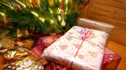 Weihnachtsgeschenke liegen unter einem geschmücktem Christbaum.