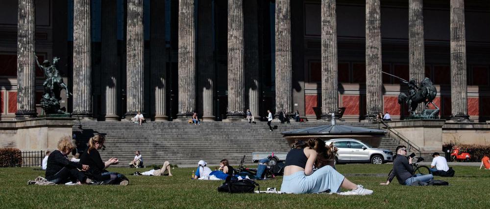 Menschen genießen das sonnige Frühjahrswetter im Lustgarten vor dem Alten Museum in Berlin.