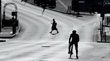 Eine Frau überquert eine leere Straße im französischen Suresnes. 