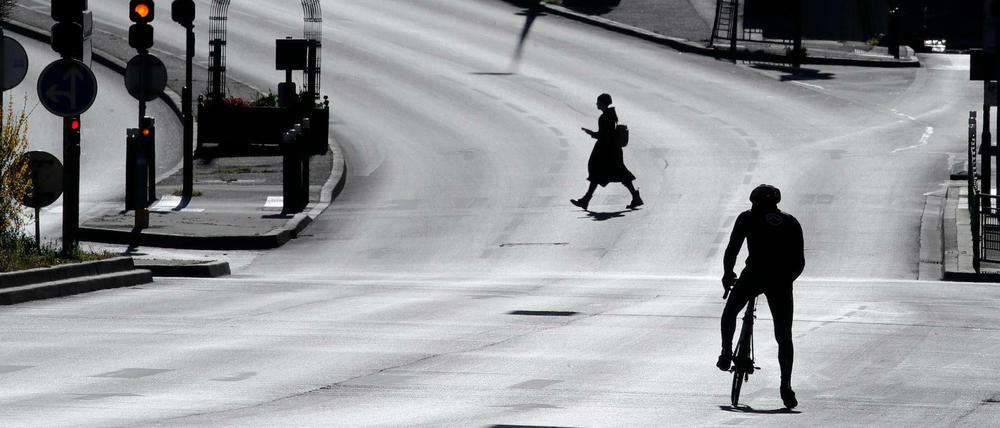 Eine Frau überquert eine leere Straße im französischen Suresnes. 
