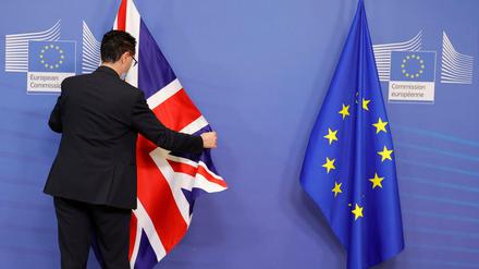 Ein Mitglied des Protokolls richtet die EU- und Fahne Großbritanniens vor einem Treffen im EU-Hauptquartier. 