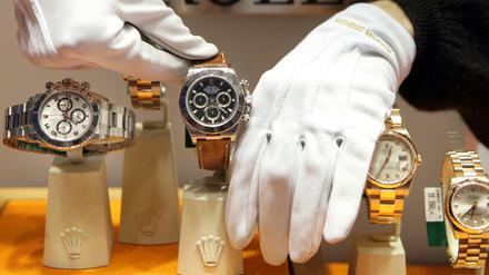 Mit weißen Handschuhen werden Luxusuhren der elitären Schweizer Uhrenmanufaktur Rolex in einem Schaufenster platziert