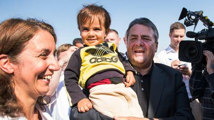 Bundeswirtschaftsminister Sigmar Gabriel (SPD) hält Muqnin, einen Flüchtlingsjungen aus Syrien, bei der Besichtigung des Flüchtlingslagers Saatari in Jordanien auf dem Arm. Links neben ihm Aydan Özoguz (SPD), Staatsministerin für Integration. 