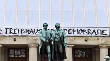 Treibhaus der Demokratie steht an der Fassade des Deutschen Nationaltheater hinter dem Goethe-Schiller-Denkmal. Hier trat vor 100 Jahren dei Nationalversammlung zusammen.