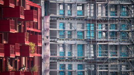  Ein Baugerüst steht an einem Rohbau neben bereits fertiggestellten Neubau-Wohnungen in Kreuzberg.