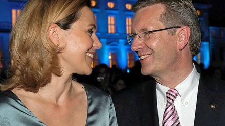 Bundespräsident Christian Wulff und seine Frau Bettina vor dem abendlich beleuchteten Schloss Bellevue.