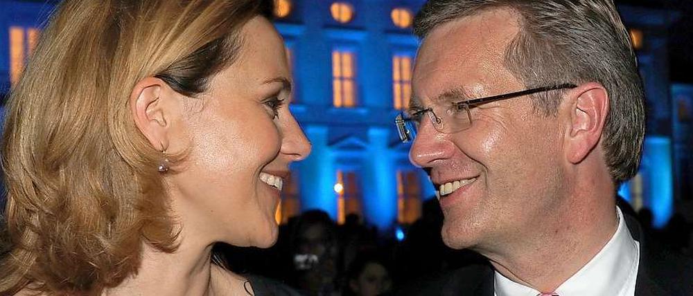 Bundespräsident Christian Wulff und seine Frau Bettina vor dem abendlich beleuchteten Schloss Bellevue.