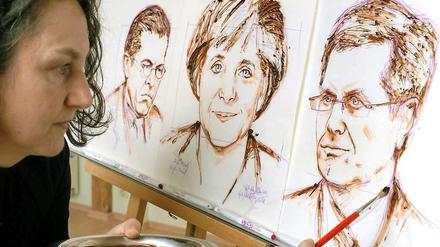 Bundeskanzlerin Angela Merkel gezeichnet von einer Schokoladenkünstlerin - inmitten der beiden Krisenpolitiker. Der eine, Karl-Theodor zu Guttenberg ist schon weg, den anderen Bundespräsident Christian Wulff verteidigt sie noch. 
