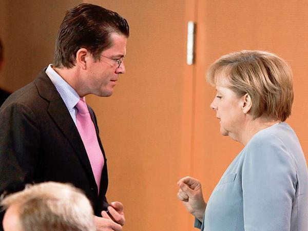 Kurz vor Beginn der Kabinettssitzung tauschen sich Bundeskanzlerin Merkel und Bundesverteidigungsminister zu Guttenberg aus.