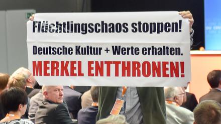 Rückendeckung sieht anders aus: Ein Mann hält beim CDU-Regionalkongress ein Plakat mit der Aufschrift "Merkel entthronen".
