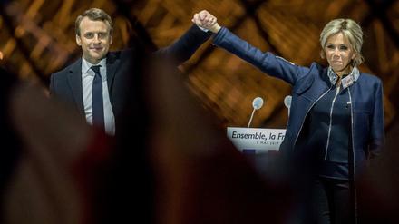 Emmanuel Macron steht nach dem Sieg bei der Präsidentenwahl mit seiner Ehefrau Brigitte auf einer Bühne am Louvre in Paris.