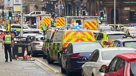 Rettungs- und Polizeifahrzeuge stehen nahe des Tatorts in Glasgow.