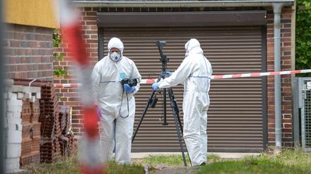 Mitarbeiter der Spurensicherung untersuchen in Glienicke/Nordbahn (Brandenburg) ein Grundstück, auf dem am 11. Juli der Leichnam einer 75-jährigen Frau entdeckt wurde.