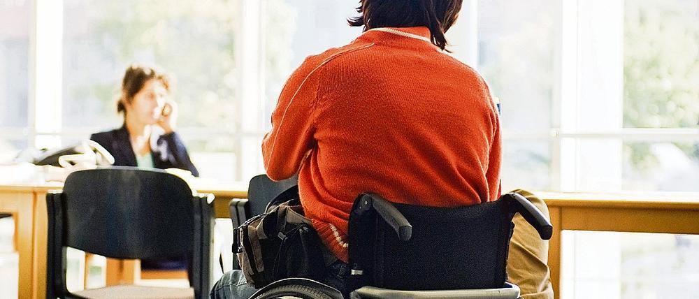 Behinderte Frau im Rollstuhl im Warteraum einer brandenburgischen Behörde.
