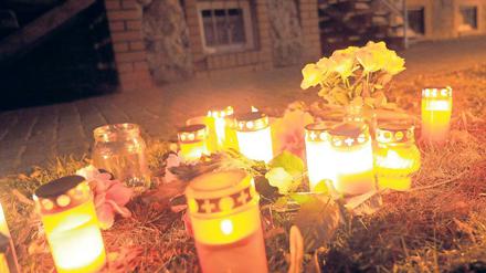 Trauer. Kerzen und Blumen vor dem Haus der ermordeten Seniorin.