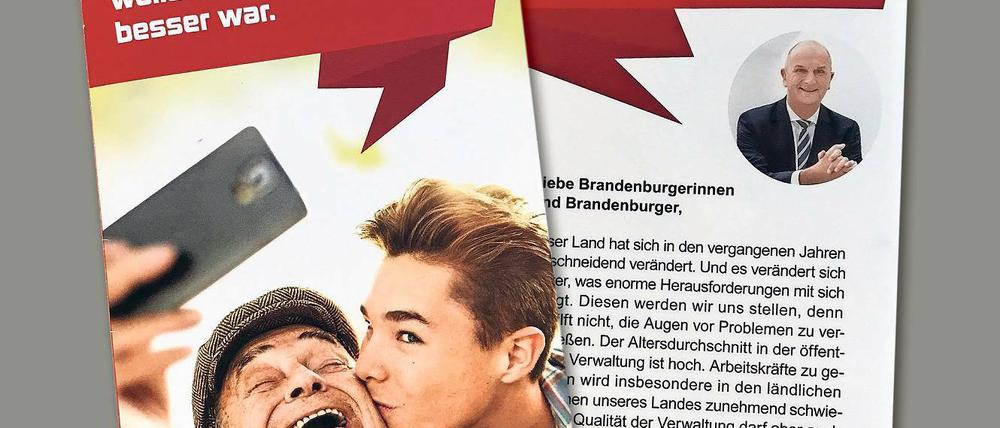 Werbematerial. Neben SPD-rotem Hintergrund grüßt Dietmar Woidke lächelnd die Brandenburger.