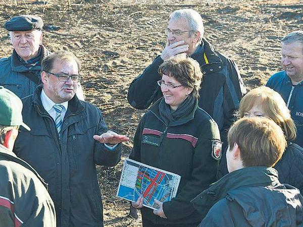 Forsträtin Karin Heintz zeigt Landwirtschaftsminister Jörg Vogelsänger auf einer Karte und in der Natur, wie die Aufforstung im Brandgebiet laufen soll.