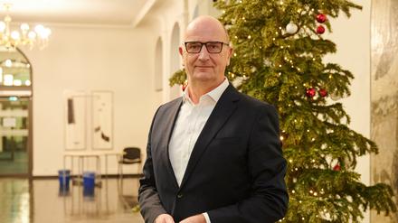 Dietmar Woidke (SPD), Ministerpräsident des Landes Brandenburg, steht im Foyer der Staatskanzlei vor dem Weihnachtsbaum.