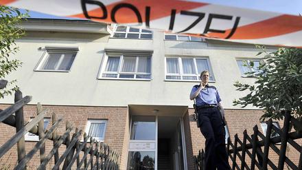 Eine Polizistin steht am Mittwoch in Velten vor einem Wohnhaus, in dem in einer Wohnung zwei Leichen entdeckt worden sind.