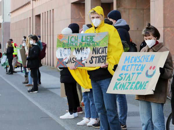 "Menschenketten statt Konzerne" - Demonstrierende mit Plakaten an der Breiten Straße.