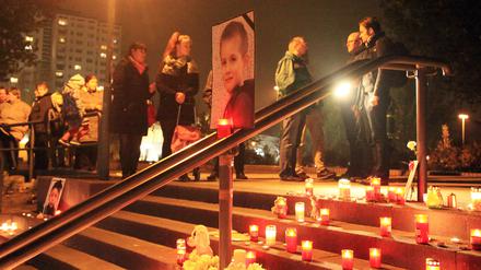 Vor einem Foto des ermordeten Elias aus Potsdam brennen während einer Gedenkfeier am Freitag vor dem Bürgerhaus in Potsdam-Schlaatz Kerzen.
