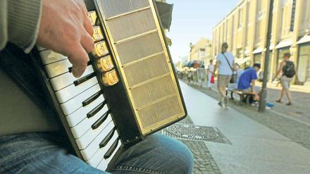 Genuss oder Qual? Ein Straßenmusiker sitzt auf der Brandenburger Straße und präsentiert seine Kunst. Gerade in den vergangenen Monaten versuchten viele dort ihr Glück.
