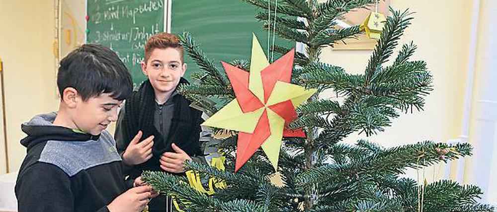 Selbst gemacht. Mit gebastelten Sternen haben geflüchtete Schüler Weihnachtsbäume geschmückt – und gleich auch noch Vokabeln rund um die Adventszeit gelernt.