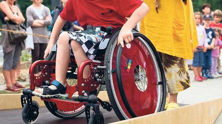 Mutig. Der achtjährige Steven fährt mit seinem Rollstuhl über eine Wippe.