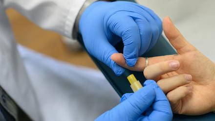 Im Labor wird einer Person Blut für einen HIV-Test entnommen (Symbolbild).