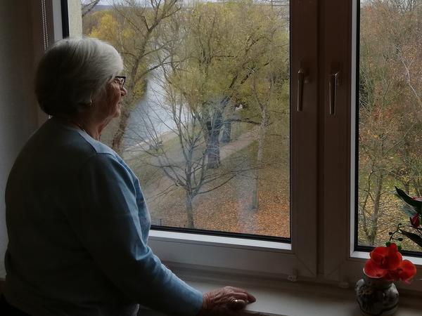 Gisela Haase blickt aus dem Fenster ihrer Einzimmerwohnung im 6. Stock.