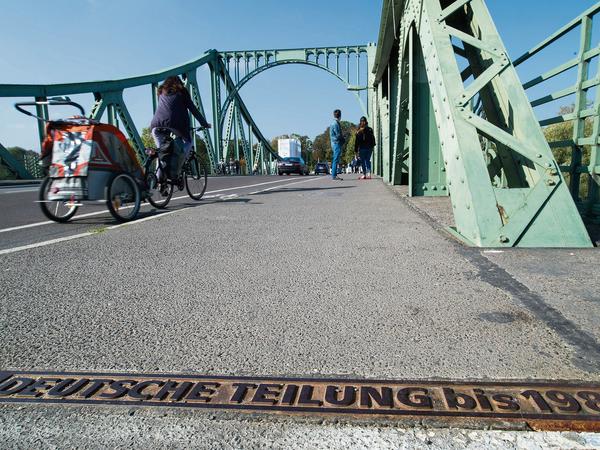 "Deutsche Teilung bis 1989" steht auf einem Metallstreifen in der Mitte der Glienicker Brücke in Potsdam.