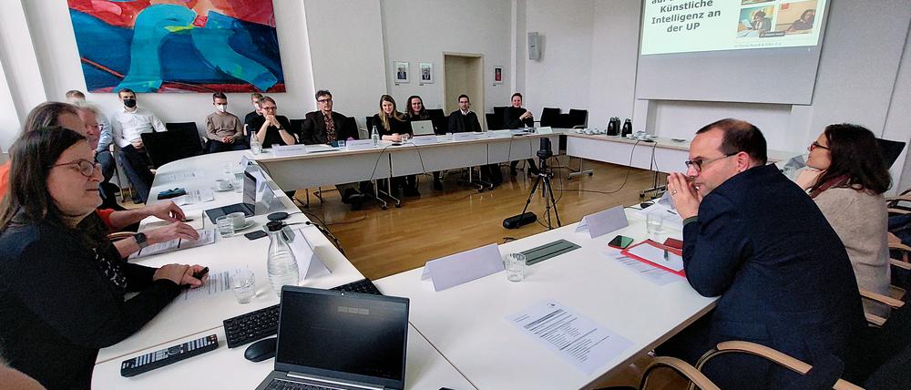 Staatssekretär Tobias Dünow informiert sich im Gespräch mit  Professorinnen und Professoren sowie Studierenden über den Einsatz von Künstlicher Intelligenz (KI) in der Forschung und Lehre an der Universität Potsdam.