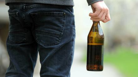 Ein Mann mit einer Bierflasche (Symbolbild).
