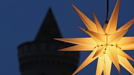 Ein Stern leuchtet vor einem Turm des Nauener Tors in Potsdam.