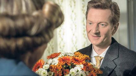 Liebe in den 50er Jahren. Thomas Müller (Michael Kessler) überrascht seine Frau Anna (Ruth Blauert) mit einem Blumenstrauß.