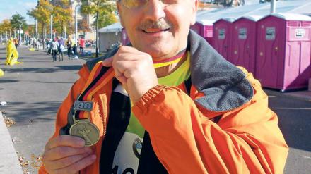 Glücklich am Ziel. Jürgen Müller nach dem Berlin-Marathon im Jahr 2013 mit seiner Finisher-Medaille.