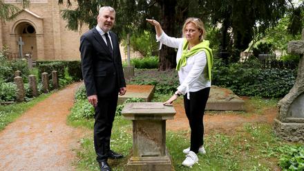 Pfarrer Friedhelm Wizisla und Ulrike Maria Bens vom Friedhof Bornstedt zeigen einen Sockel, von dem eine Sandsteinvase entwendet wurde. 