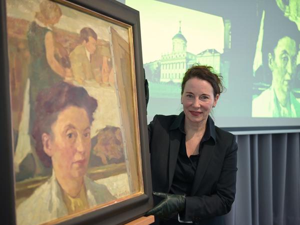 Jutta Götzmann neben dem Gemälde "Selbstporträt vor Abend über Potsdam" von Lotte Laserstein, eine Schenkung an das Potsdam Museum.