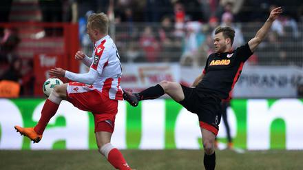 Unions Kristian Pedersen (l) und Regensburgs Benedikt Saller kämpfen um den Ball.