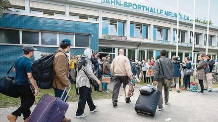 Neue, temporäre Heimat: Flüchtlinge kommen an der Jahnsporthalle am Columbiadamm an.