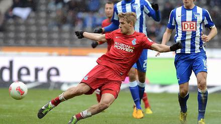 Sören Brandy behauptet im roten Trikot des MSV Duisburg den Ball gegen zwei Hertha-Spieler.